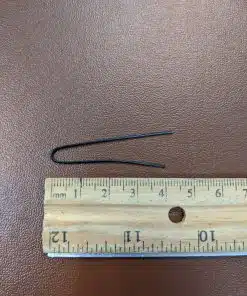 Vinyl coated steel bent twist tie being measured with a ruler at 4 inches.