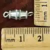 Silver barrel magnetic clasp with loop ends shown next to ruler for size scale