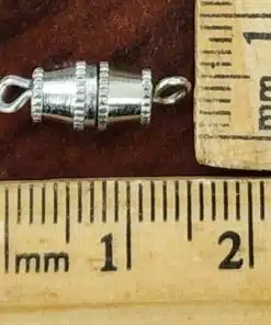 Silver barrel magnetic clasp with loop ends shown next to ruler for size scale